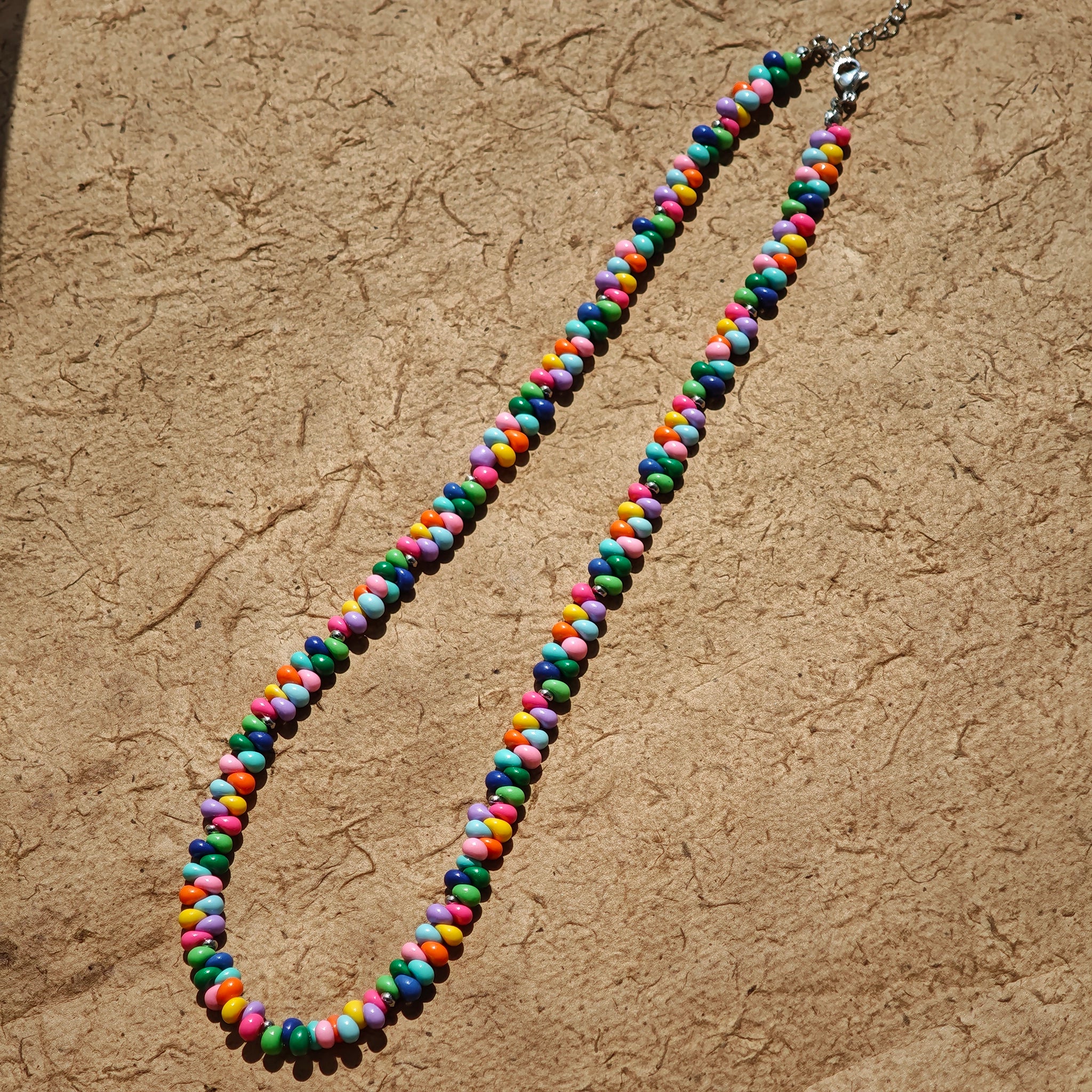 This is a bead necklace that consists of colorful peanut shape beads. It's as colorful as rainbow.