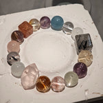 This multi gemstone bracelet features aquamarine, amethyst, strawberry quartz, rose quartz, green phantom quartz, and black rutilated quartz.