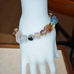This multi gemstone bracelet features aquamarine, amethyst, strawberry quartz, rose quartz, green phantom quartz, and black rutilated quartz.