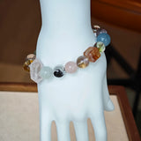 This multi gemstone bracelet features aquamarine, amethyst, strawberry quartz, rose quartz, green phantom quartz, and black rutilated quartz.