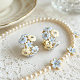 These 18k gold-plated stud/clip earrings feature delicate blossoms crafted with enamel glaze and inlaid with sparkling zircon stones. The combination of soft blue, creamy yellow and lustrous gold creates a romantic and feminine look that captures the essence of blooming florals.