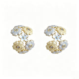 These 18k gold-plated stud/clip earrings feature delicate blossoms crafted with enamel glaze and inlaid with sparkling zircon stones. The combination of soft blue, creamy yellow and lustrous gold creates a romantic and feminine look that captures the essence of blooming florals.