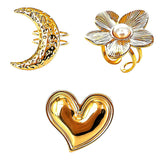This 18K gold‑plated stainless steel ring set features bold sculpted designs of flowers, a puffy heart, swirling sun, and hammered crescent moon. Some flower rings are accented with a lustrous faux pearl for extra vintage charm. These open adjustable statement rings deliver a chunky retro aesthetic for everyday and special‑occasion styling.