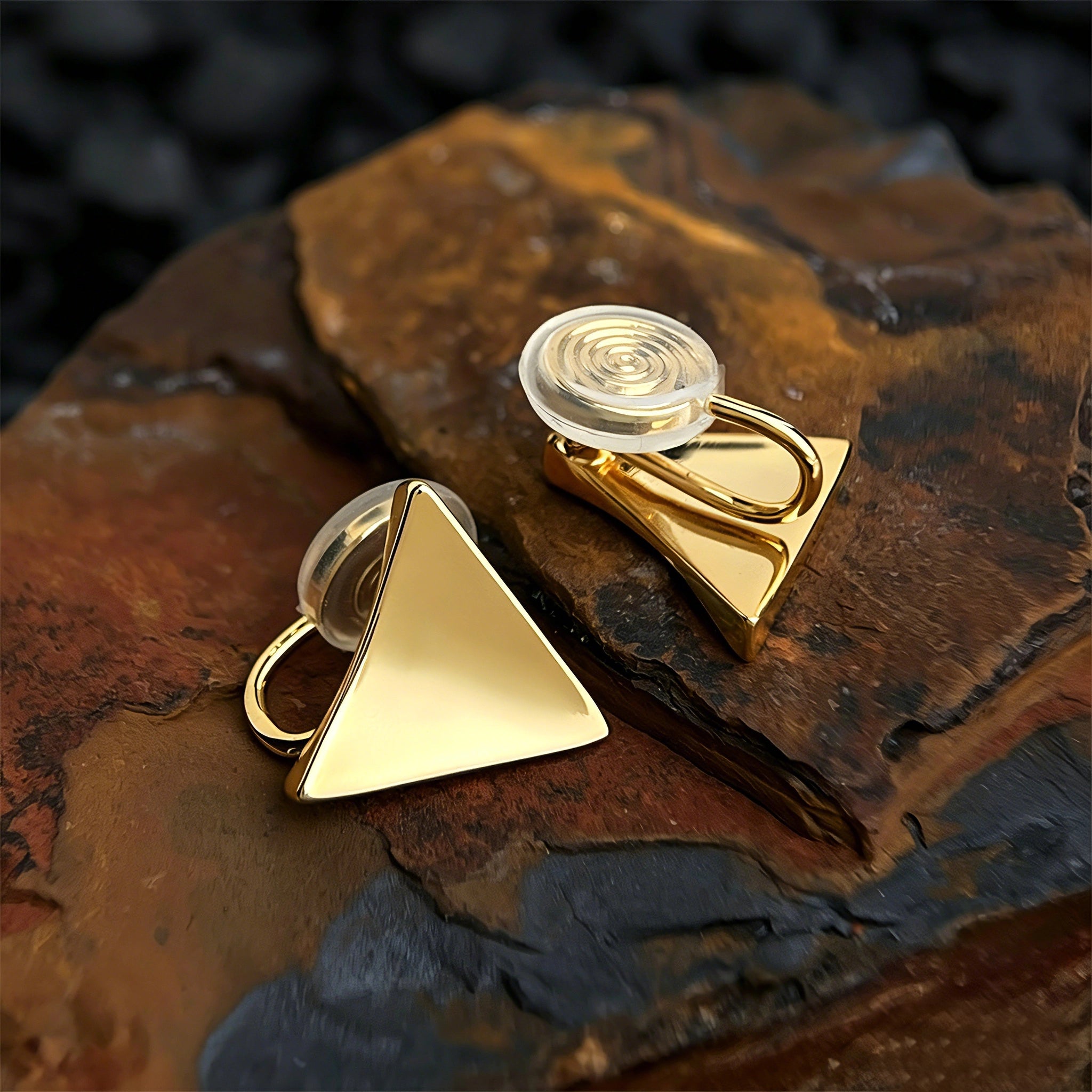 These thick 18K gold-plated stud earrings feature a sleek, modern curved triangle design with smooth, polished surfaces that catch the light beautifully. The sculpted, slightly concave shape creates a three-dimensional effect, adding subtle depth and dimension to the minimalist geometric silhouette.