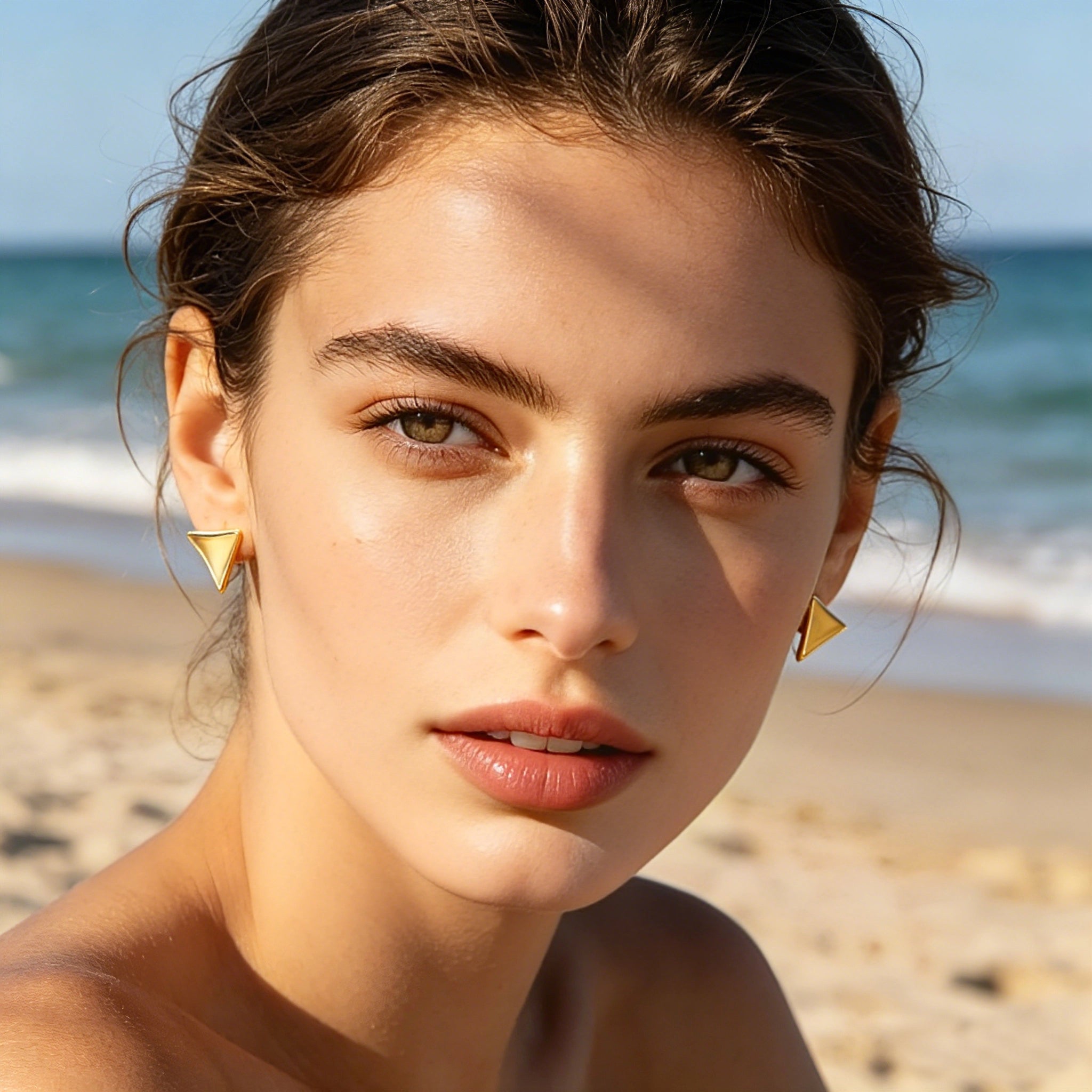 These thick 18K gold-plated stud earrings feature a sleek, modern curved triangle design with smooth, polished surfaces that catch the light beautifully. The sculpted, slightly concave shape creates a three-dimensional effect, adding subtle depth and dimension to the minimalist geometric silhouette.