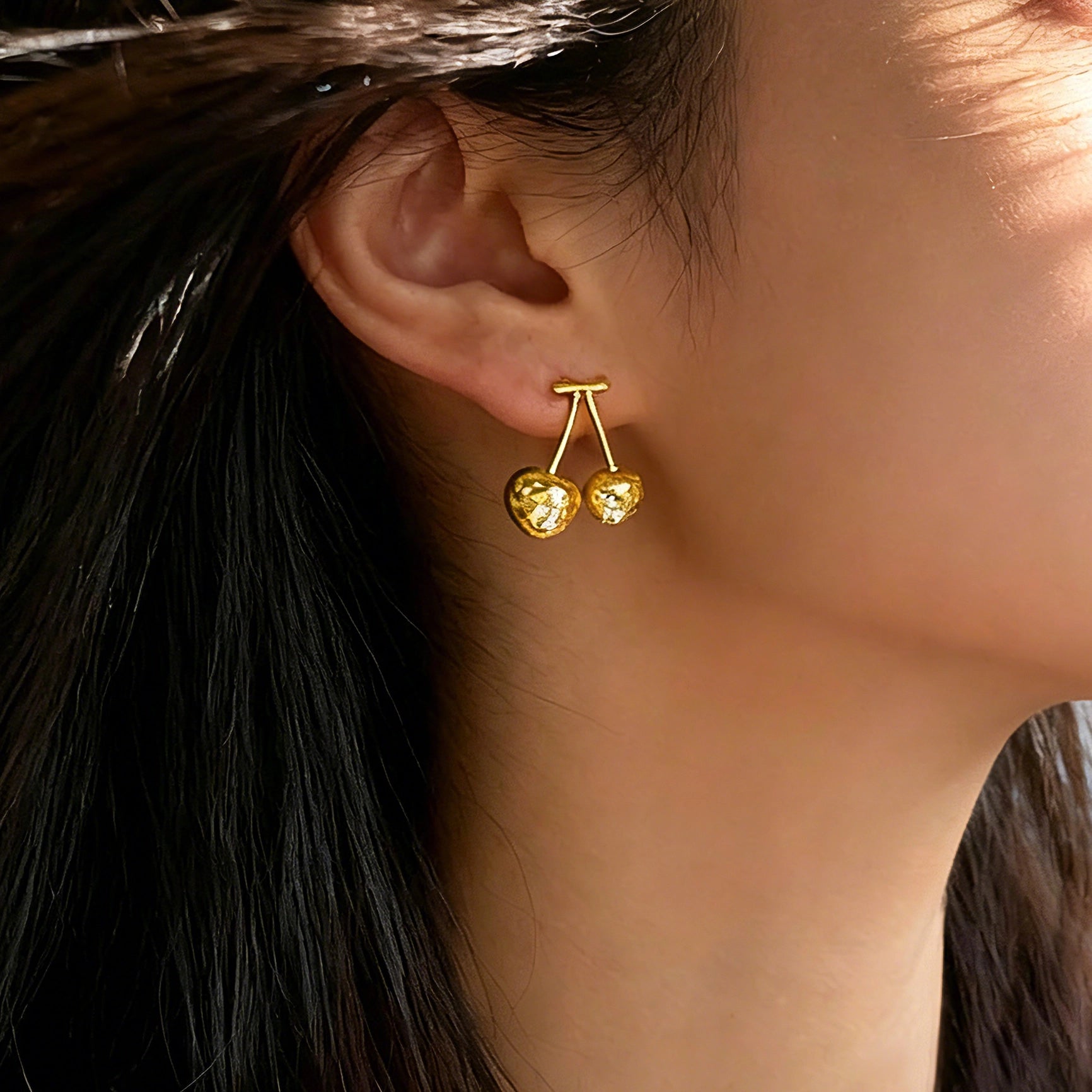 These cherry-shaped stud earrings feature a luxurious matte sandblasted finish, crafted from thick-plated real gold over 925 sterling silver posts. Each earring is designed as a pair of cherries, adorned with a marquise-cut and a round-cut sparkling clear stone, adding a delicate, eye-catching sparkle. The playful, organic cherry silhouette and premium gold plating make them a chic, elegant accessory for everyday wear.