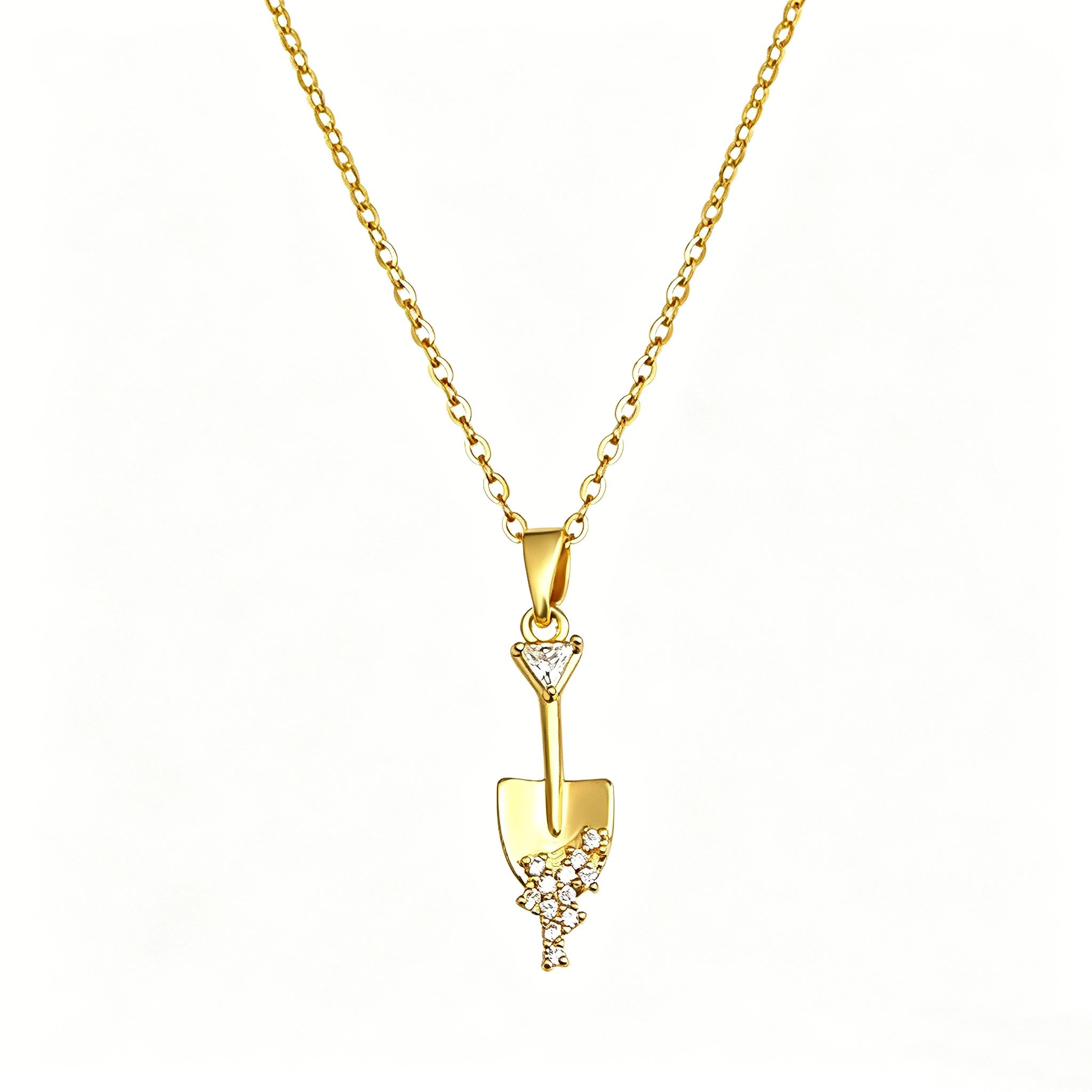 This is a necklace featuring a unique shovel-shaped pendant crafted with thick 18K gold plating, exuding a luxurious golden luster. The pendant is adorned with delicate micro-paved cubic zirconia stones, which sparkle brightly against the gold surface. Designed as a dainty pendant necklace, it showcases a sleek, minimalist style with intricate detailing on the shovel head and handle.
