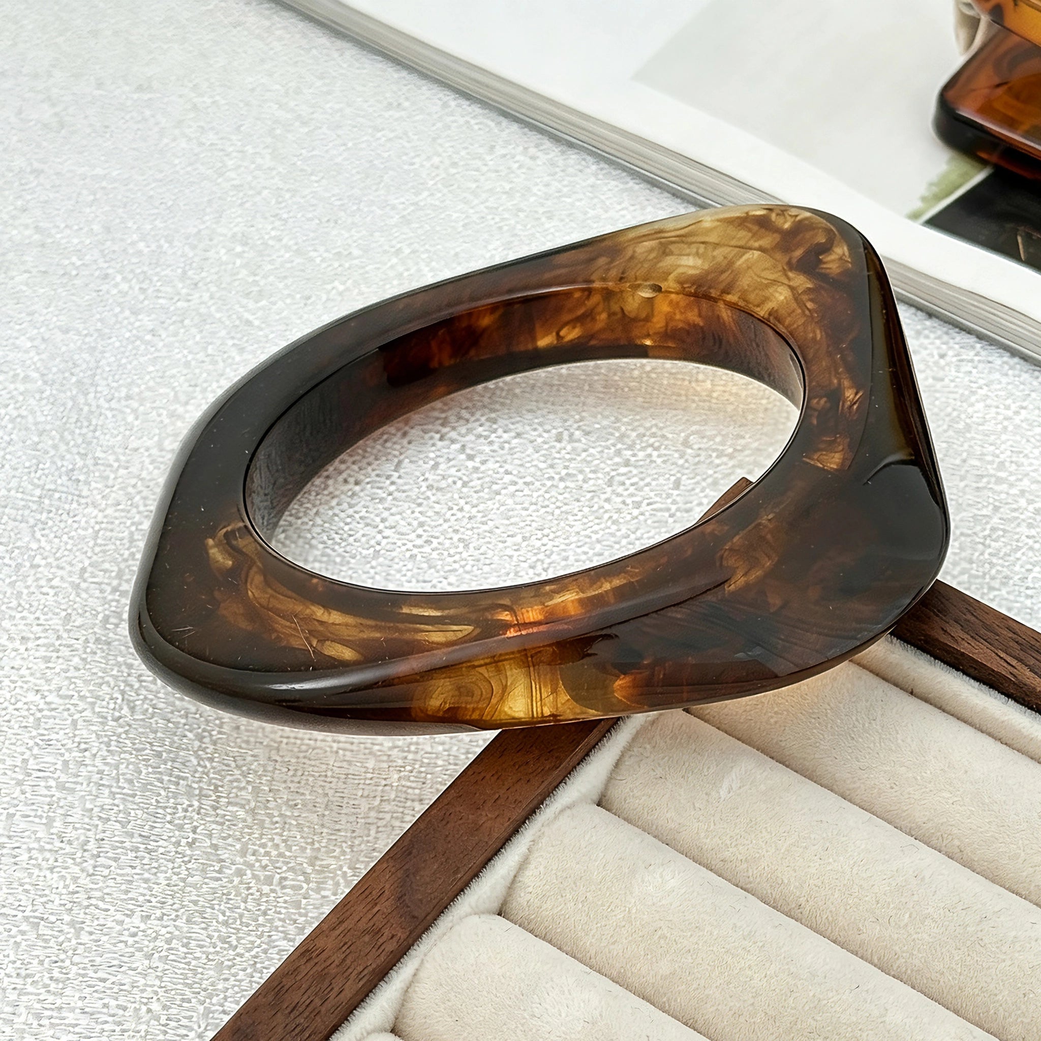 Crafted from translucent acrylic, these amber marbled bangles feature organic swirling tones for a vintage aesthetic. The 3-piece set includes varied shapes that stack beautifully, adding earthy retro charm to any outfit. Smooth, polished surfaces deliver a lightweight, comfortable wearing experience.