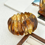 Crafted from translucent acrylic, these amber marbled bangles feature organic swirling tones for a vintage aesthetic. The 3-piece set includes varied shapes that stack beautifully, adding earthy retro charm to any outfit. Smooth, polished surfaces deliver a lightweight, comfortable wearing experience.
