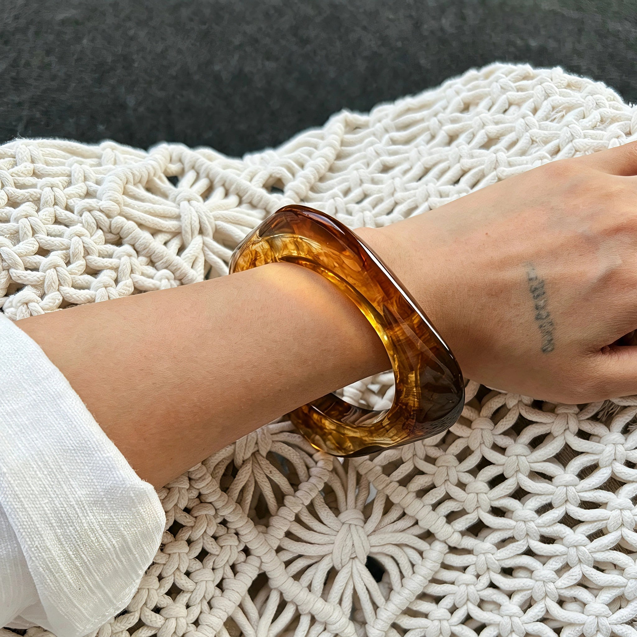Crafted from translucent acrylic, these amber marbled bangles feature organic swirling tones for a vintage aesthetic. The 3-piece set includes varied shapes that stack beautifully, adding earthy retro charm to any outfit. Smooth, polished surfaces deliver a lightweight, comfortable wearing experience.