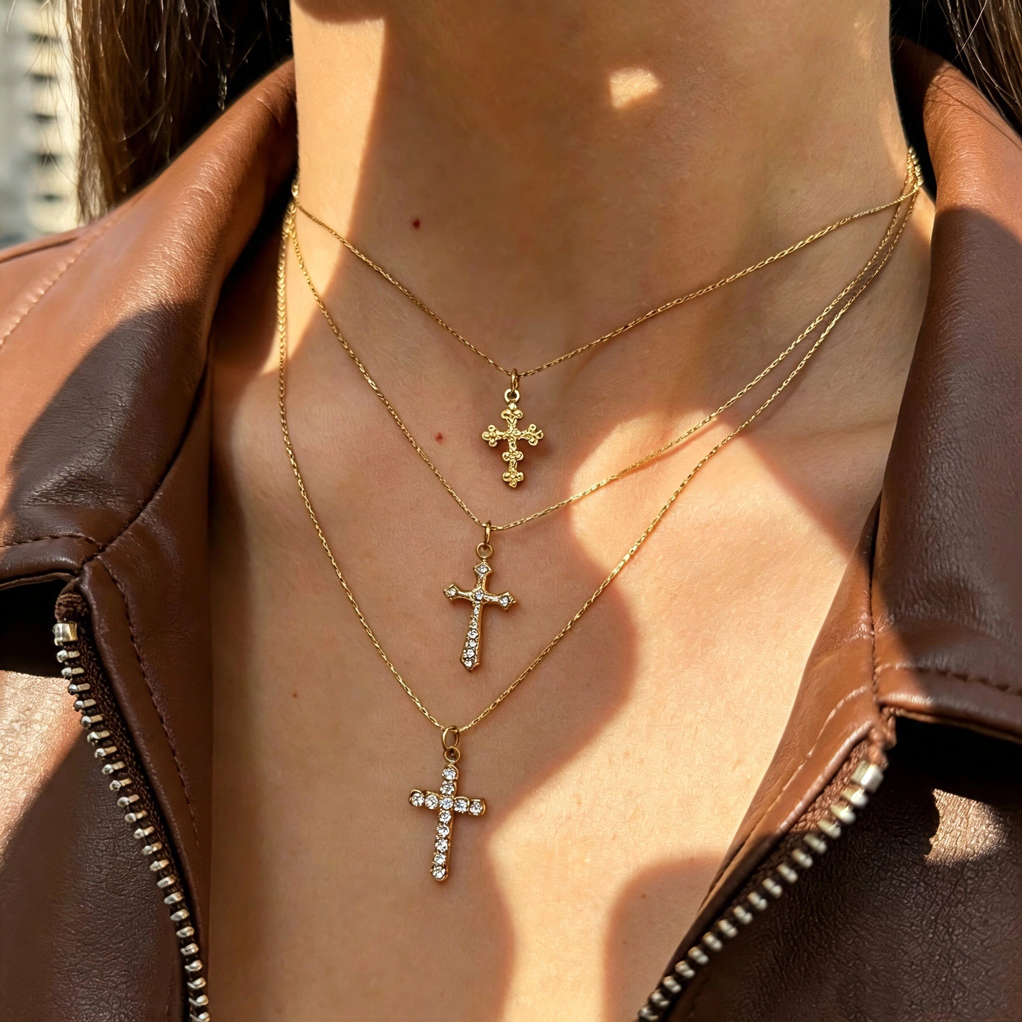 This 3-piece stainless steel cross necklace set features three distinct cross pendants, including crystal-encrusted styles and an ornate floral cross. Crafted in polished gold tone, the delicate thin chains are perfect for trendy layered stacking looks. Waterproof and durable, these dainty cross necklaces deliver timeless vintage charm for everyday wear.