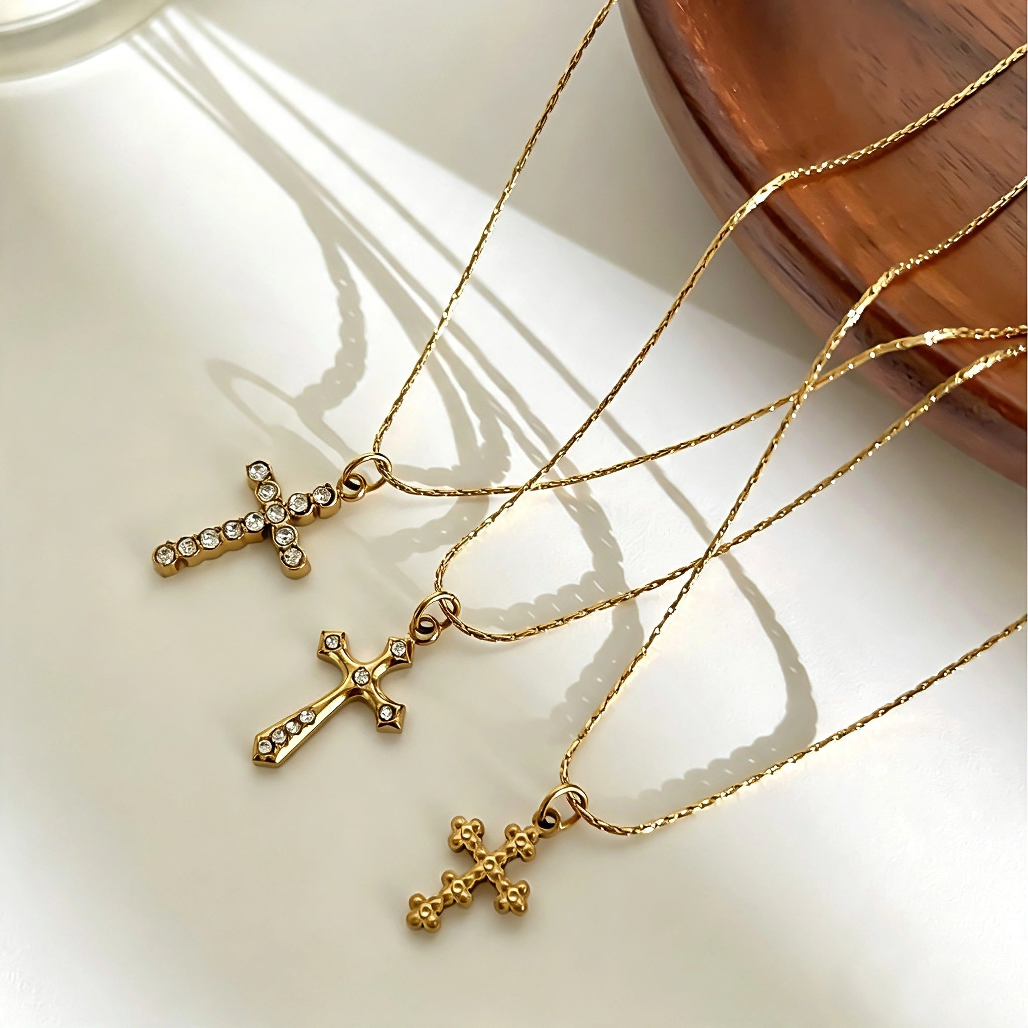 This 3-piece stainless steel cross necklace set features three distinct cross pendants, including crystal-encrusted styles and an ornate floral cross. Crafted in polished gold tone, the delicate thin chains are perfect for trendy layered stacking looks. Waterproof and durable, these dainty cross necklaces deliver timeless vintage charm for everyday wear.