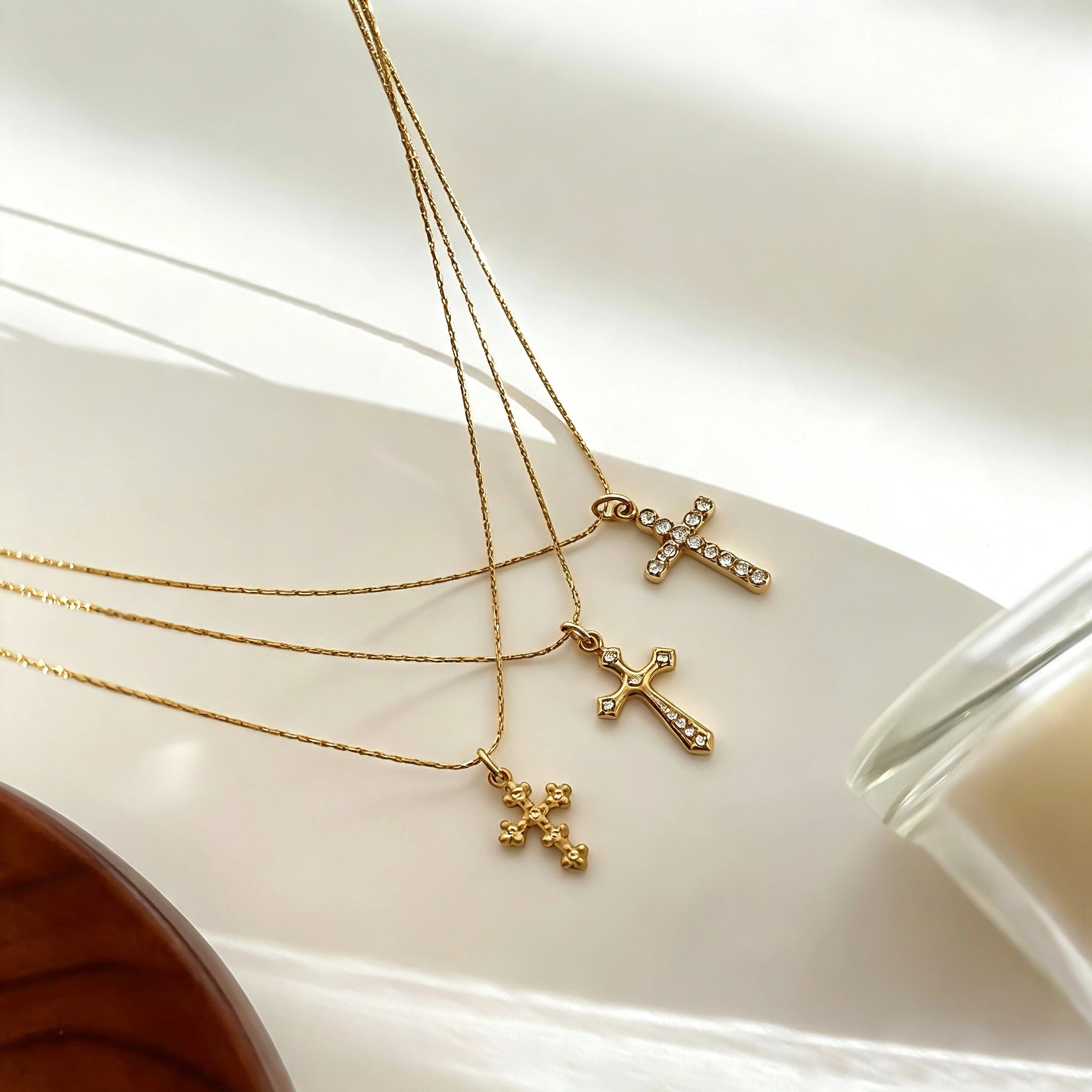 This 3-piece stainless steel cross necklace set features three distinct cross pendants, including crystal-encrusted styles and an ornate floral cross. Crafted in polished gold tone, the delicate thin chains are perfect for trendy layered stacking looks. Waterproof and durable, these dainty cross necklaces deliver timeless vintage charm for everyday wear.