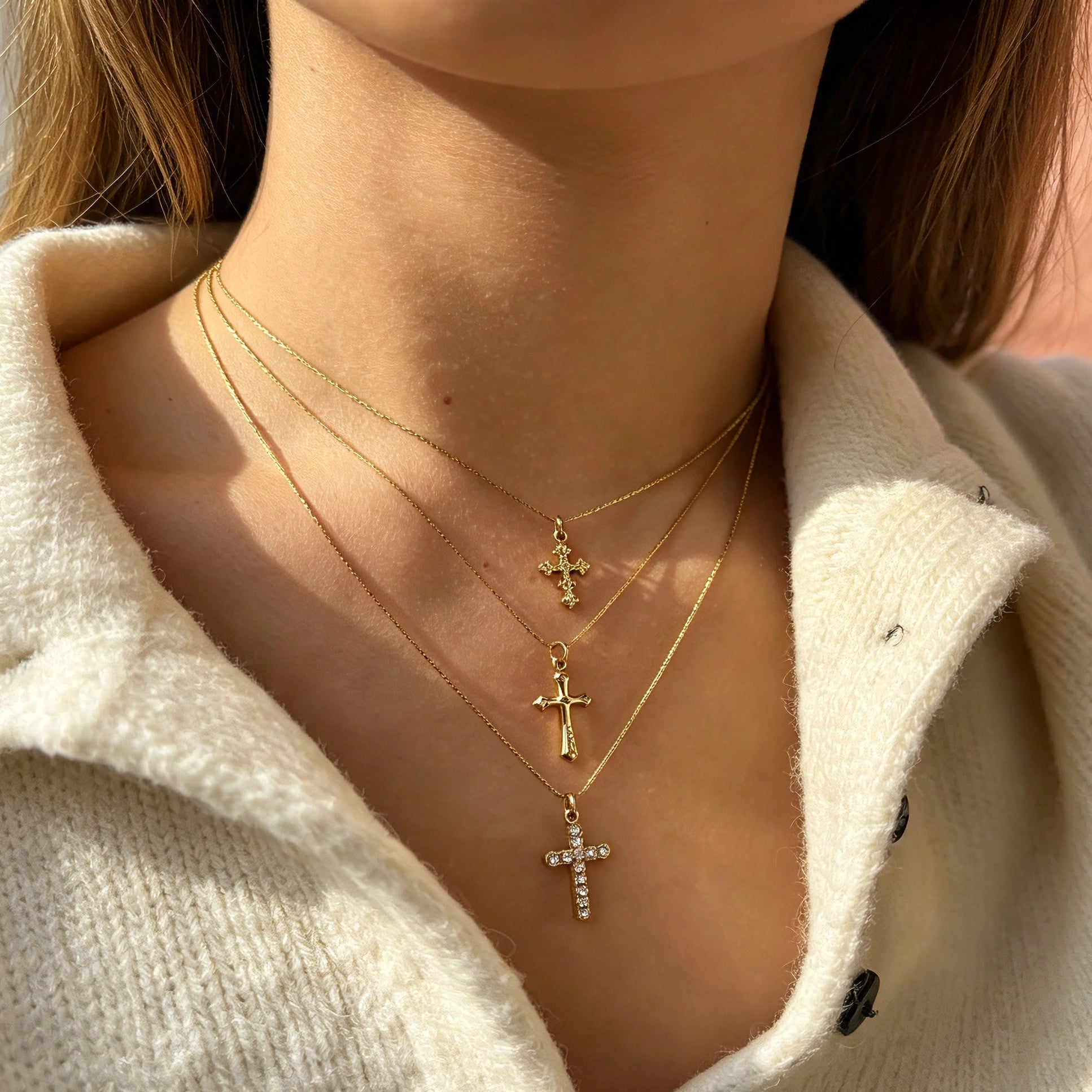 This 3-piece stainless steel cross necklace set features three distinct cross pendants, including crystal-encrusted styles and an ornate floral cross. Crafted in polished gold tone, the delicate thin chains are perfect for trendy layered stacking looks. Waterproof and durable, these dainty cross necklaces deliver timeless vintage charm for everyday wear.
