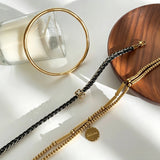 This vintage-inspired 3-piece bracelet set features a wavy gold bangle, engraved stainless steel bead chain and mixed black braided cord bracelet. Crafted from durable stainless steel, this stackable jewelry delivers timeless east-meets-west aesthetics for effortless layered styling. It is a versatile everyday accessory to elevate casual and chic outfits.