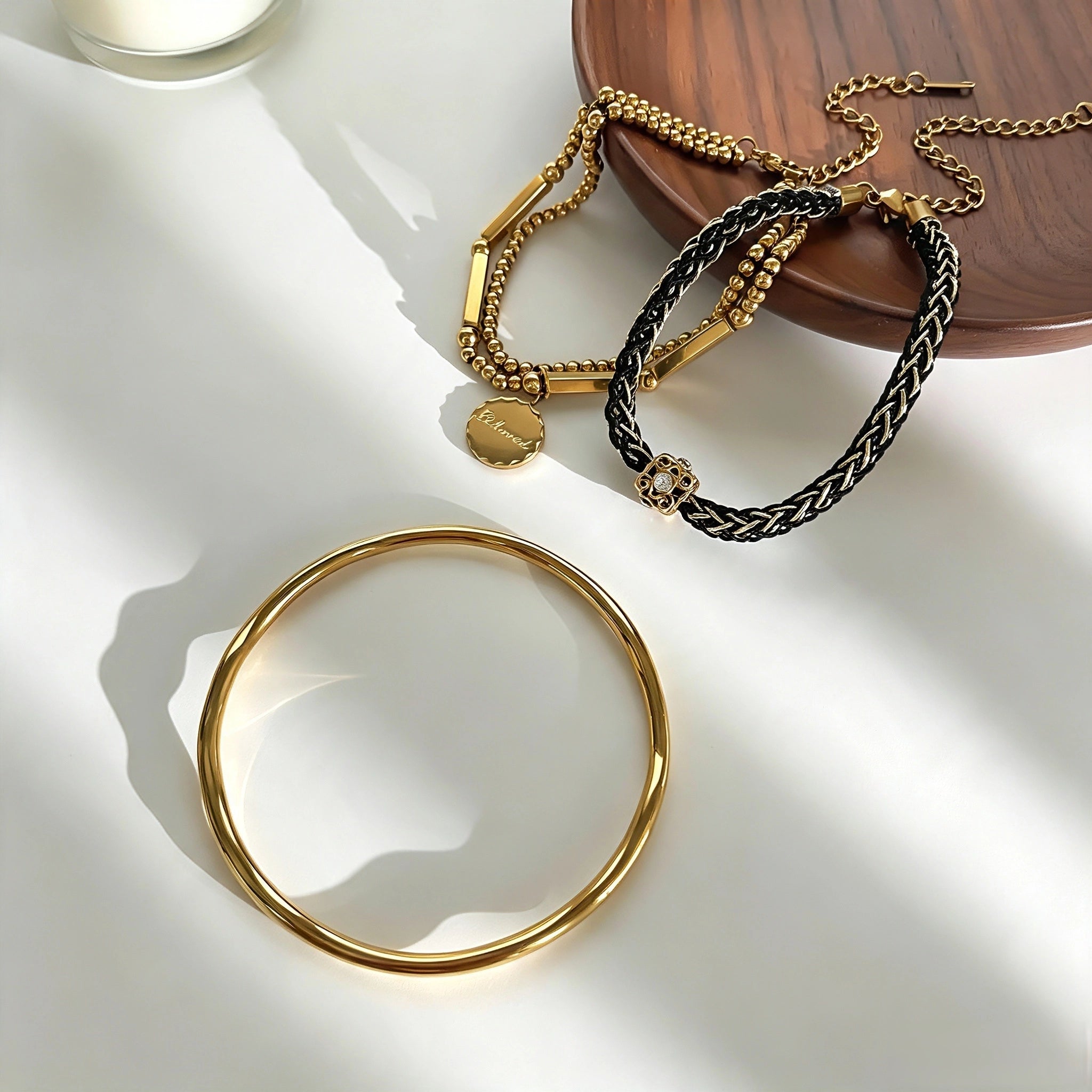 This vintage-inspired 3-piece bracelet set features a wavy gold bangle, engraved stainless steel bead chain and mixed black braided cord bracelet. Crafted from durable stainless steel, this stackable jewelry delivers timeless east-meets-west aesthetics for effortless layered styling. It is a versatile everyday accessory to elevate casual and chic outfits.