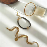 This vintage-inspired 3-piece bracelet set features a wavy gold bangle, engraved stainless steel bead chain and mixed black braided cord bracelet. Crafted from durable stainless steel, this stackable jewelry delivers timeless east-meets-west aesthetics for effortless layered styling. It is a versatile everyday accessory to elevate casual and chic outfits.