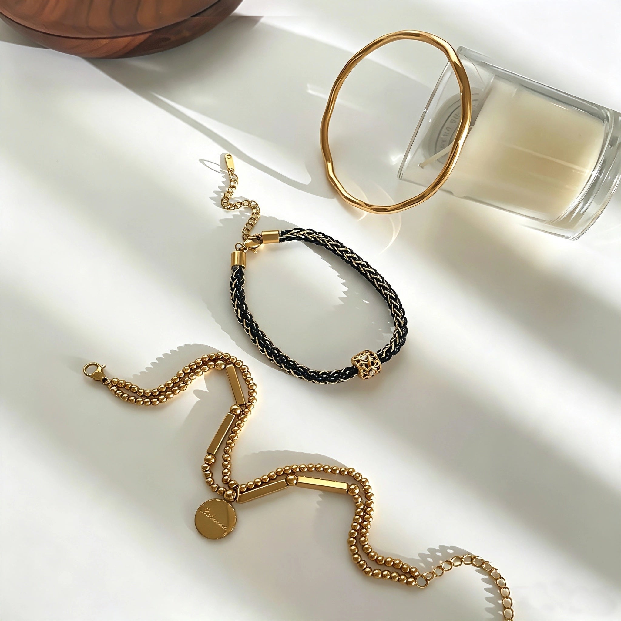This vintage-inspired 3-piece bracelet set features a wavy gold bangle, engraved stainless steel bead chain and mixed black braided cord bracelet. Crafted from durable stainless steel, this stackable jewelry delivers timeless east-meets-west aesthetics for effortless layered styling. It is a versatile everyday accessory to elevate casual and chic outfits.