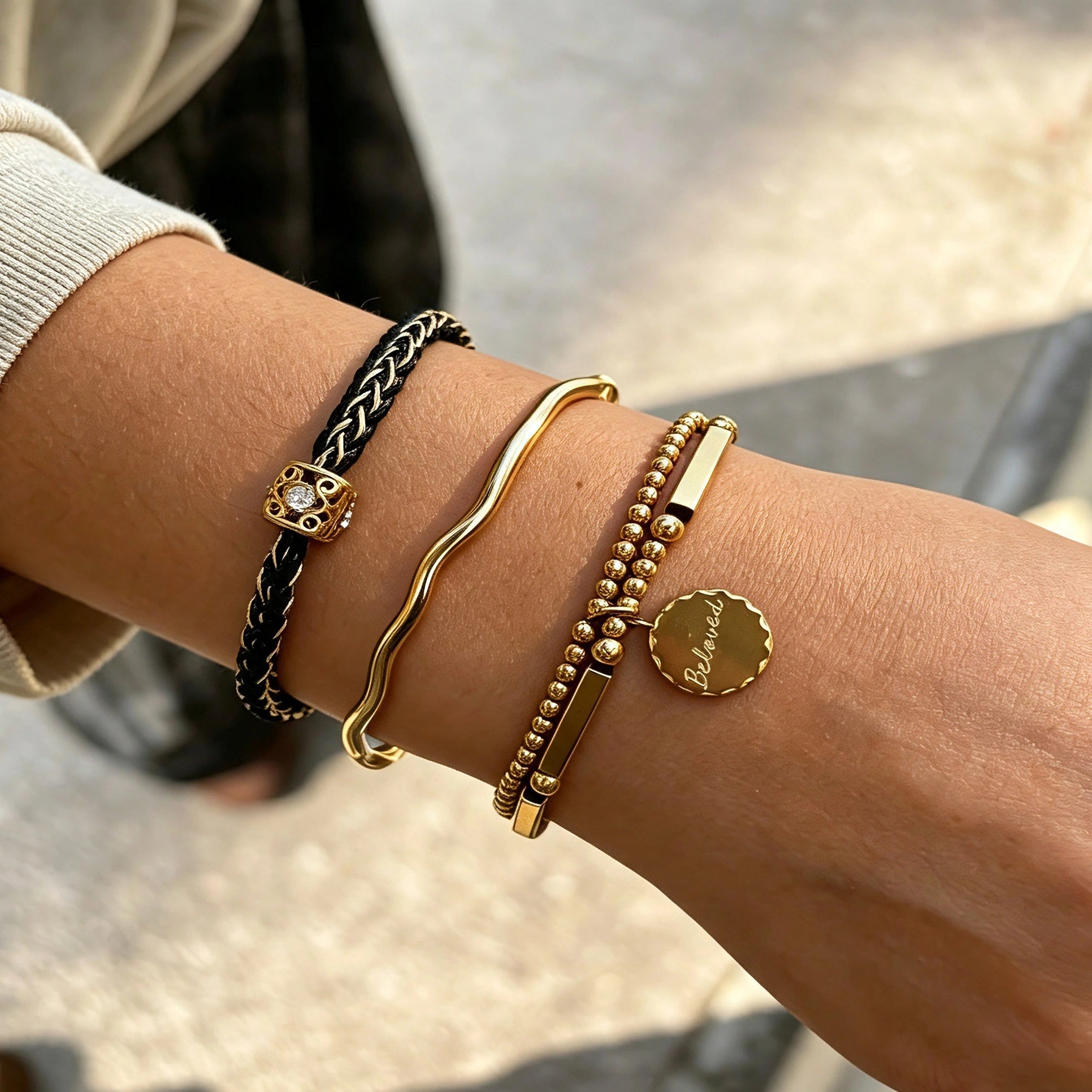 This vintage-inspired 3-piece bracelet set features a wavy gold bangle, engraved stainless steel bead chain and mixed black braided cord bracelet. Crafted from durable stainless steel, this stackable jewelry delivers timeless east-meets-west aesthetics for effortless layered styling. It is a versatile everyday accessory to elevate casual and chic outfits.
