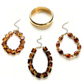 This 4-piece stackable bracelet set blends glossy tortoiseshell-pattern glass beads with polished stainless steel hardware. It includes flower-shaped, square, and oval beaded bracelets paired with a flexible gold-tone ribbed bangle. Perfect for layered styling, these warm earthy-toned accessories effortlessly elevate everyday and evening outfits.