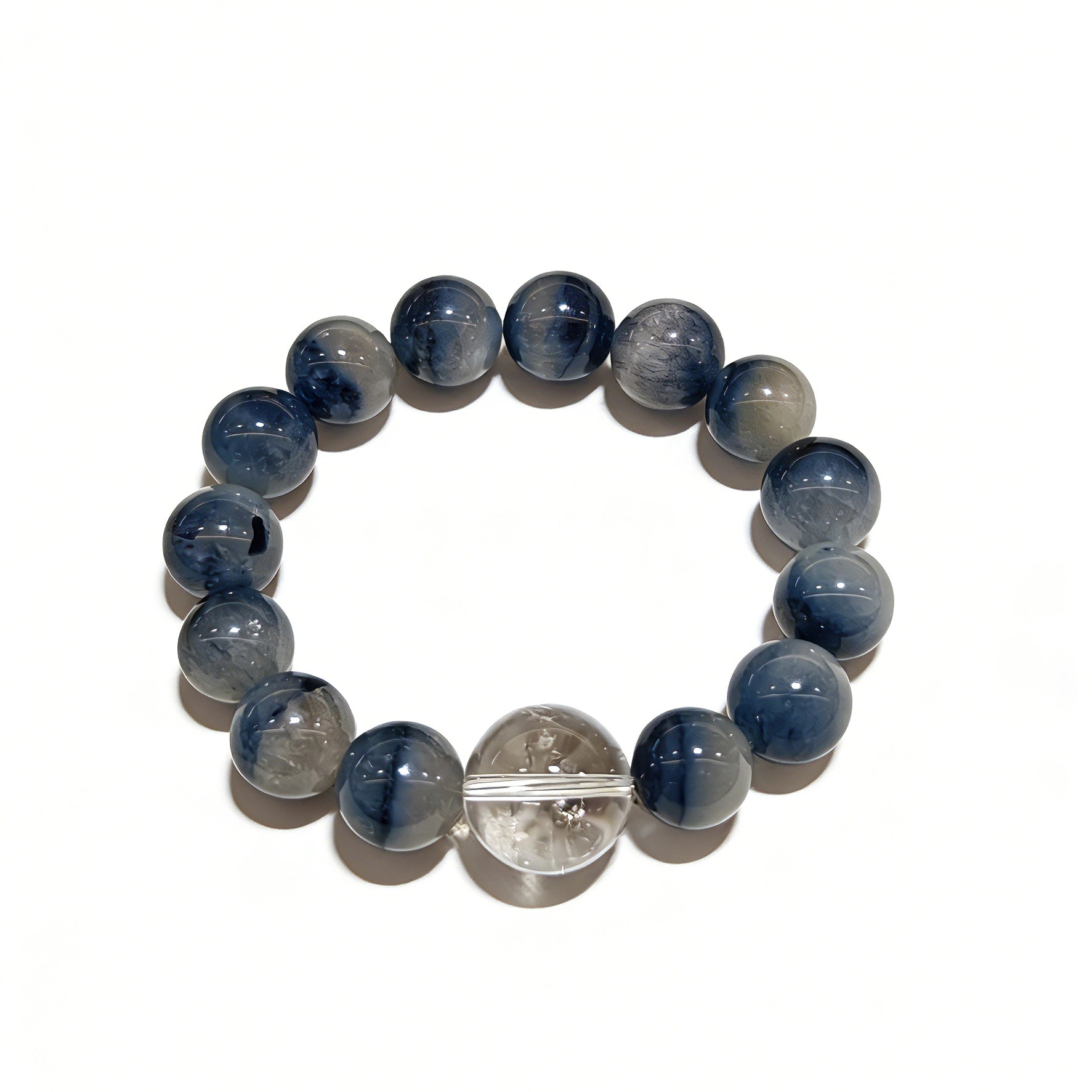 Blue rabbit hair and clear quartz beaded bracelet, featuring blue-gray rabbit hair quartz beads and a clear quartz focal bead, strung together in a circular design.
