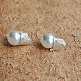This minimalist pair of silver pearl stud earrings cleverly combine a chic silver heart-shaped pendant (11.7 mm wide) with a striking pearl teardrop (total height: 19.4 mm), with the pearl beneath the heart, creating a unique and stylish silhouette.