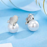 This minimalist pair of silver pearl stud earrings cleverly combine a chic silver heart-shaped pendant (11.7 mm wide) with a striking pearl teardrop (total height: 19.4 mm), with the pearl beneath the heart, creating a unique and stylish silhouette.