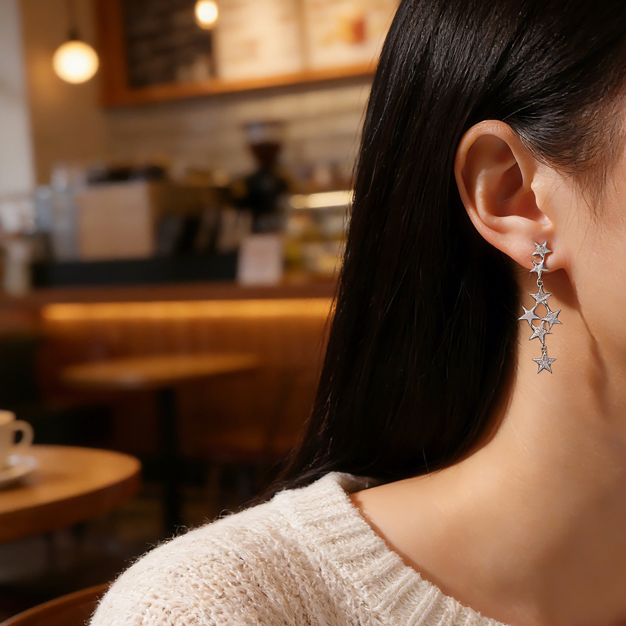 These 925 sterling silver tassel earrings showcase a star-themed design with multiple dangling stars of different sizes. Sparkling moissanite embellishments adorn some star surfaces, enhancing their luxurious and eye-catching appearance. The tassel-style structure creates a graceful, flowing silhouette with a dynamic, elegant look.