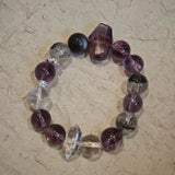 An amethyst bracelet accented with herkimer diamond, clear quartz and silver sheen obsidian.
