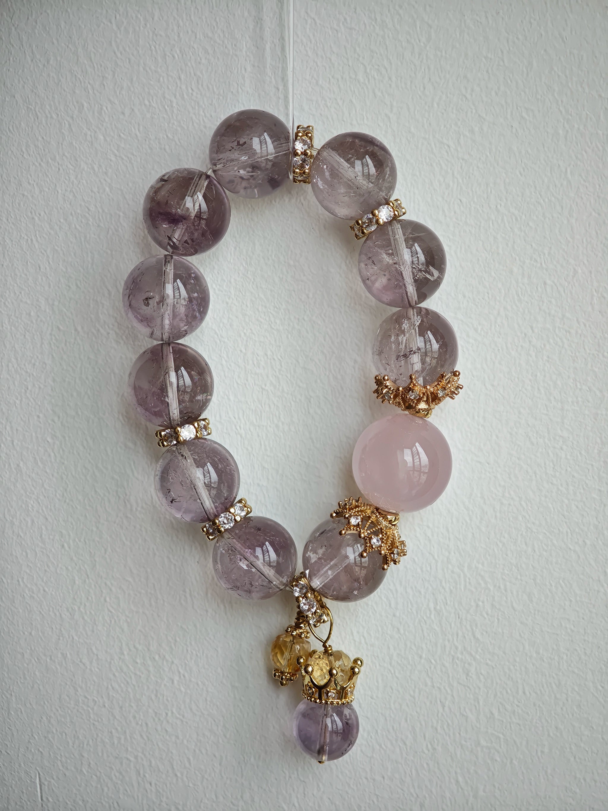 This is a bracelet featuring high-clarity amethyst, rose quartz, and citrine. It's an elegant look of pure peace.