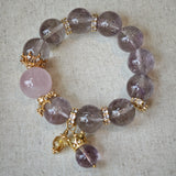 This is a bracelet featuring high-clarity amethyst, rose quartz, and citrine. It's an elegant look of pure peace.