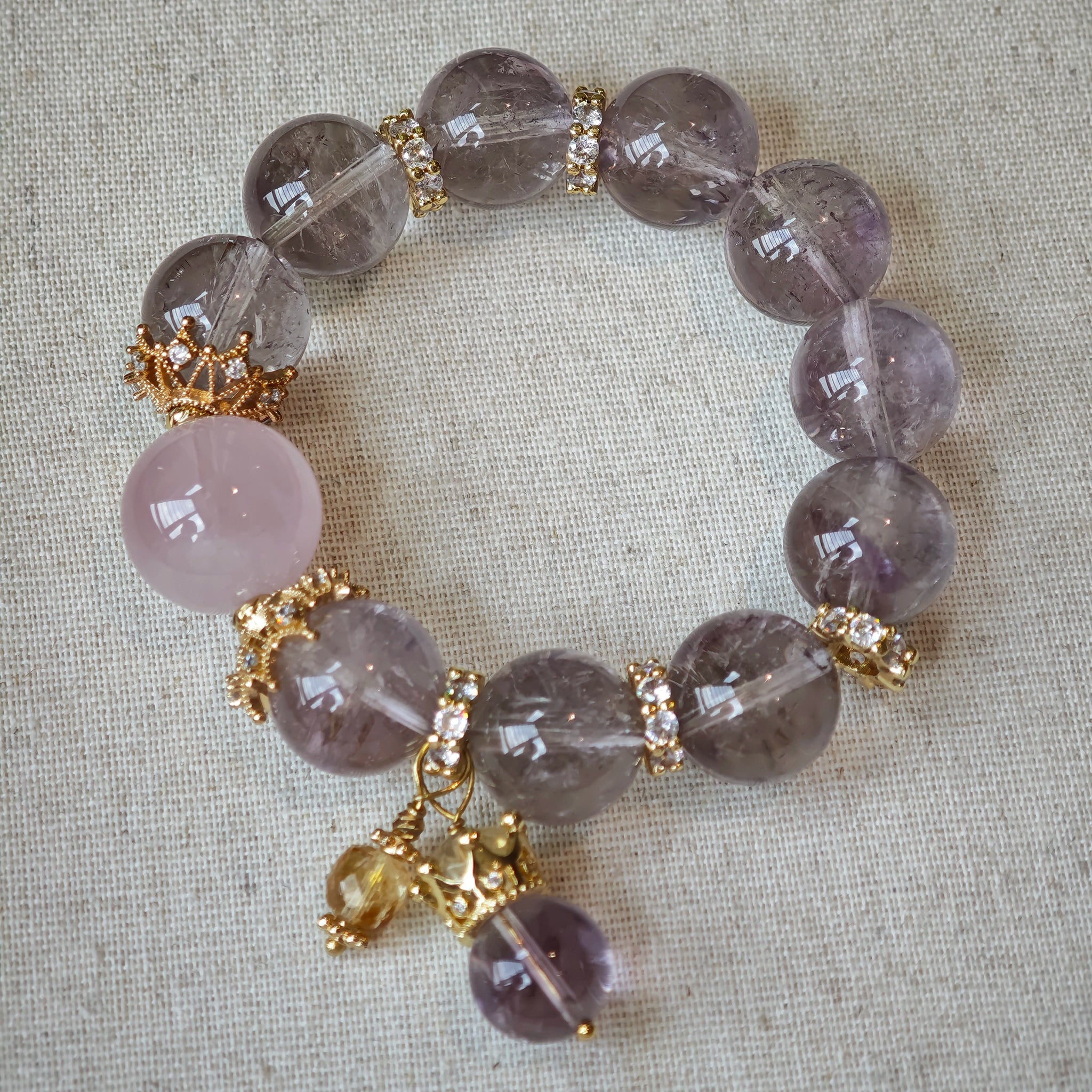 This is a bracelet featuring high-clarity amethyst, rose quartz, and citrine. It's an elegant look of pure peace.