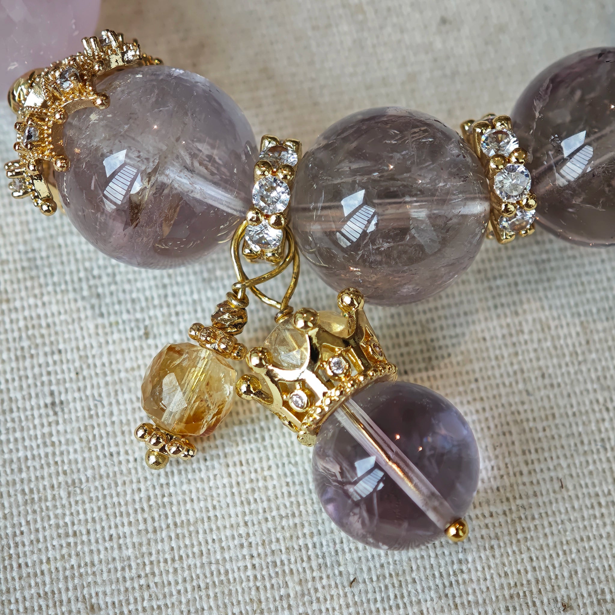 This is a bracelet featuring high-clarity amethyst, rose quartz, and citrine. It's an elegant look of pure peace.