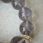 This is a bracelet featuring high-clarity amethyst, rose quartz, and citrine. It's an elegant look of pure peace.