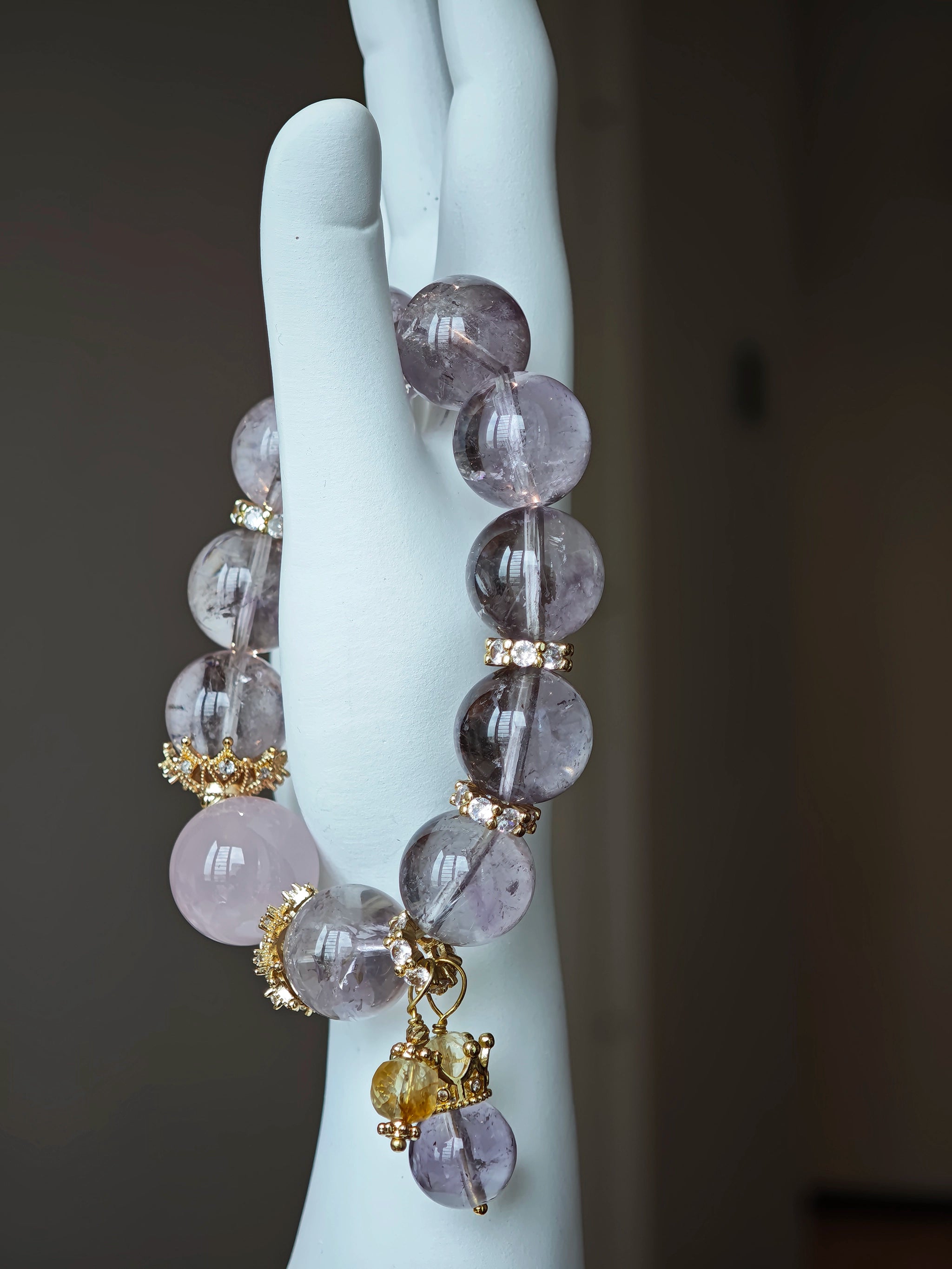 This is a bracelet featuring high-clarity amethyst, rose quartz, and citrine. It's an elegant look of pure peace.