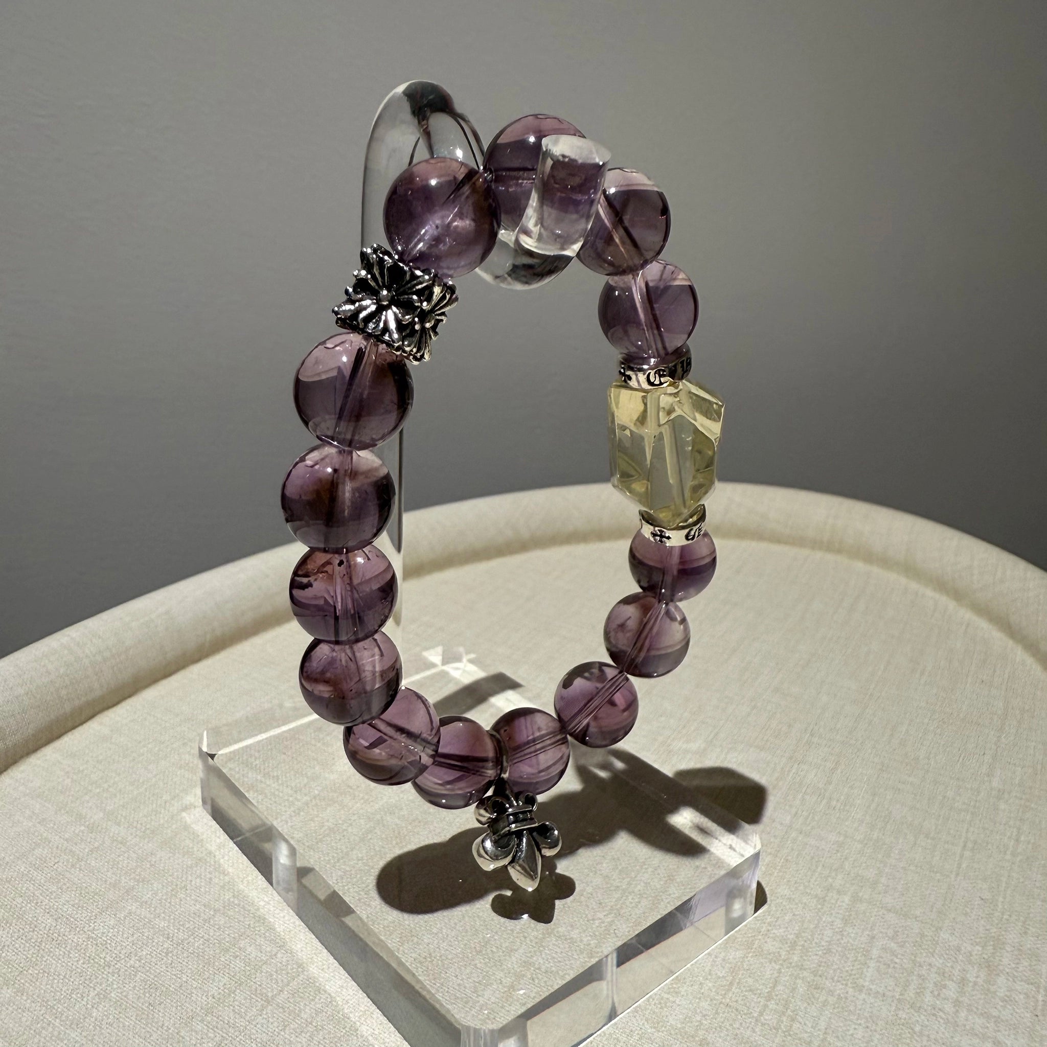 This handmade crystal bracelet alternates dreamy amethyst with a single vibrant citrine, its sterling accents flickering like fireflies.