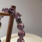 A purple parade of 14 amethyst beads pauses at a citrine sun, surrounded by sterling constellations—celestial poetry on a crystal bracelet.