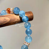 This is a gemstone bracelet that consists of 19pcs of 7-8mm aquamarine beads and 1pcs of red rutilated quartz. There are also 2 silver spacer beads in the bracelet. The main color of the bracelet is sky blue. The entire bracelet is translucent and beautiful.