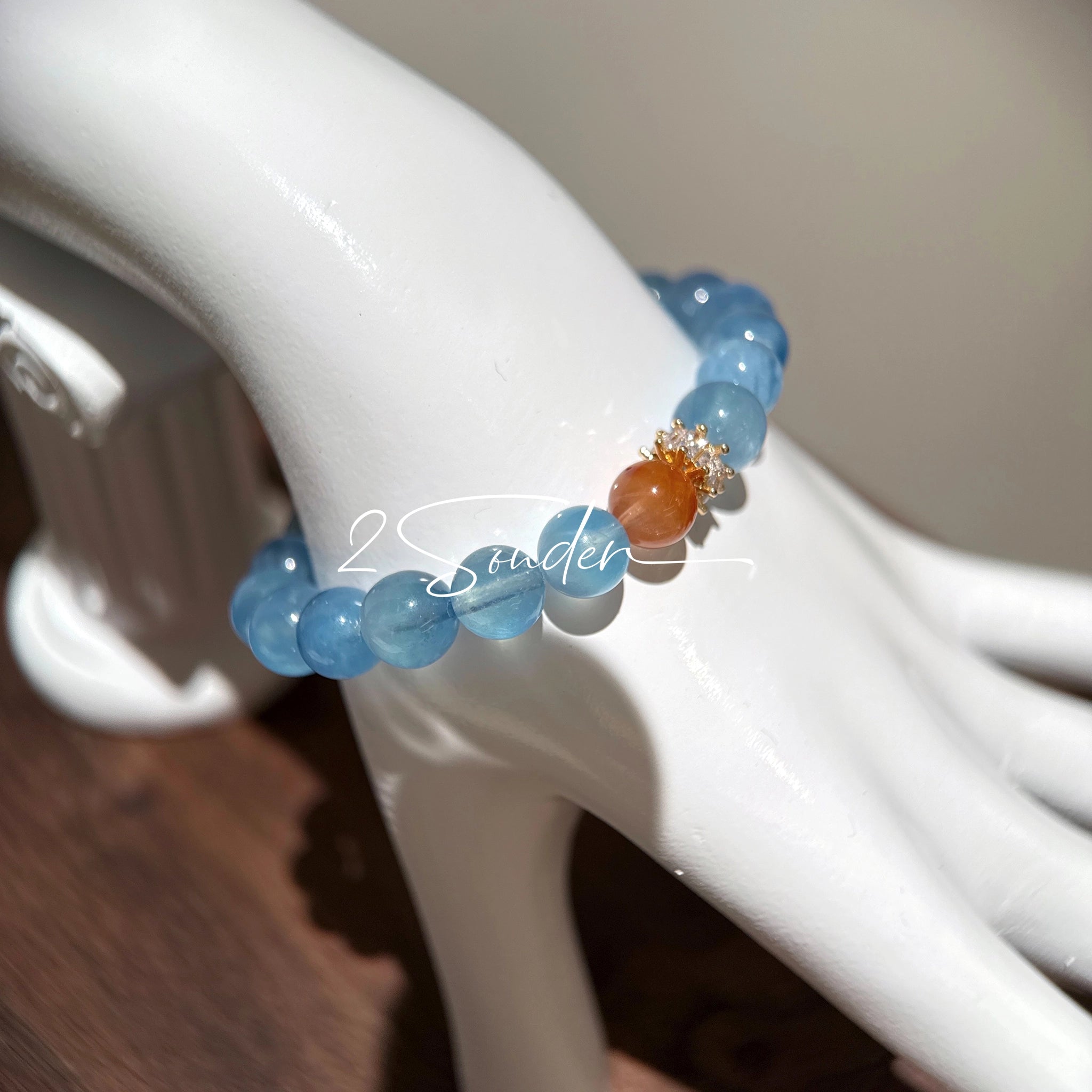 This is a gemstone bracelet that consists of 19pcs of 7-8mm aquamarine beads and 1pcs of red rutilated quartz. There are also 2 silver spacer beads in the bracelet. The main color of the bracelet is sky blue. The entire bracelet is translucent and beautiful.
