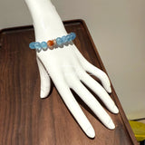 This is a gemstone bracelet that consists of 19pcs of 7-8mm aquamarine beads and 1pcs of red rutilated quartz. There are also 2 silver spacer beads in the bracelet. The main color of the bracelet is sky blue. The entire bracelet is translucent and beautiful.