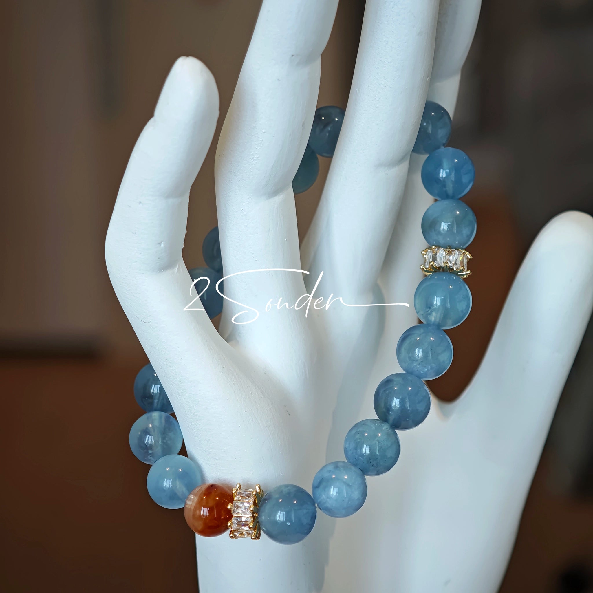 This is a gemstone bracelet that consists of 19pcs of 7-8mm aquamarine beads and 1pcs of red rutilated quartz. There are also 2 silver spacer beads in the bracelet. The main color of the bracelet is sky blue. The entire bracelet is translucent and beautiful.