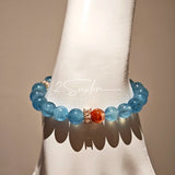 This is a gemstone bracelet that consists of 19pcs of 7-8mm aquamarine beads and 1pcs of red rutilated quartz. There are also 2 silver spacer beads in the bracelet. The main color of the bracelet is sky blue. The entire bracelet is translucent and beautiful.