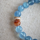 This is a gemstone bracelet that consists of 19pcs of 7-8mm aquamarine beads and 1pcs of red rutilated quartz. There are also 2 silver spacer beads in the bracelet. The main color of the bracelet is sky blue. The entire bracelet is translucent and beautiful.