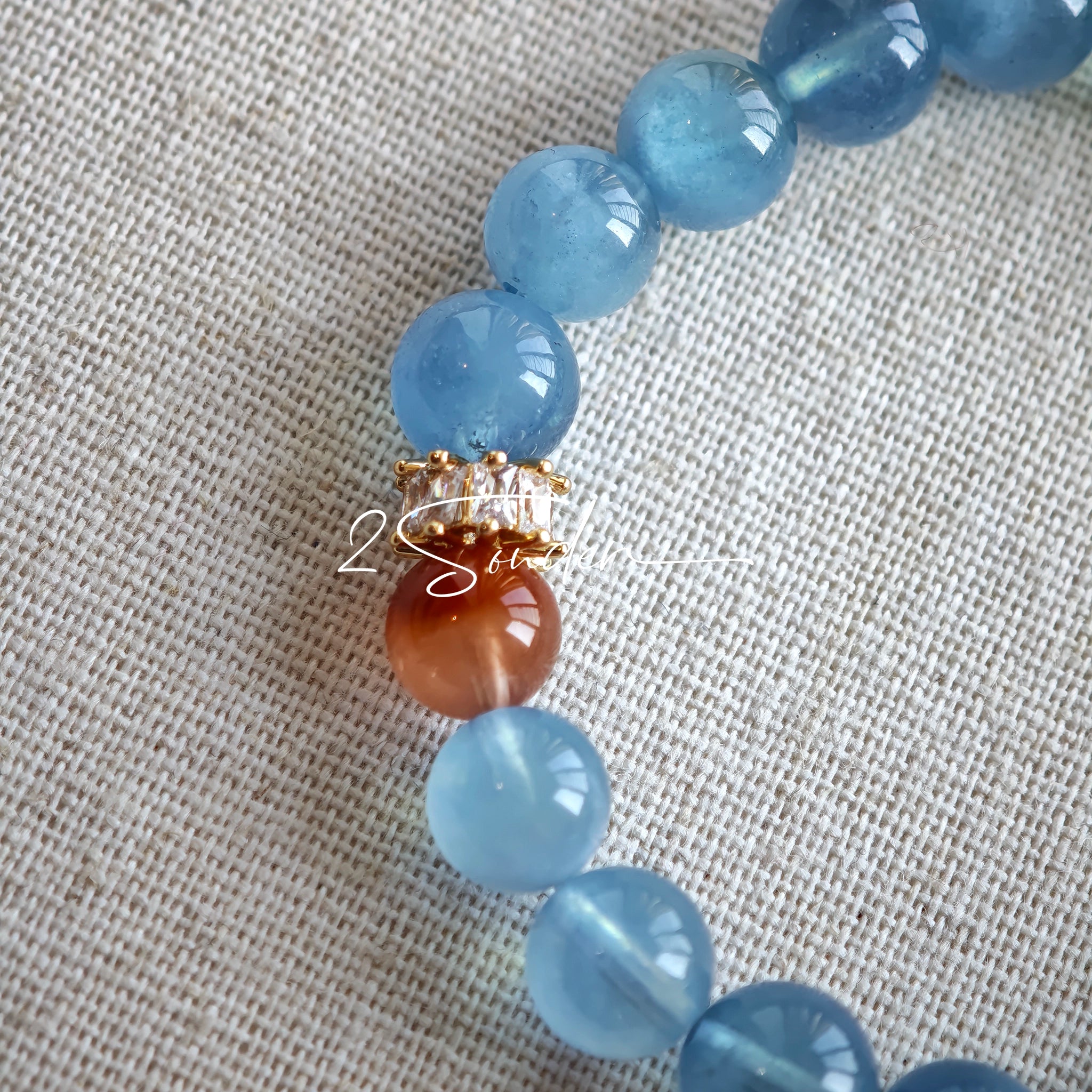 This is a gemstone bracelet that consists of 19pcs of 7-8mm aquamarine beads and 1pcs of red rutilated quartz. There are also 2 silver spacer beads in the bracelet. The main color of the bracelet is sky blue. The entire bracelet is translucent and beautiful.