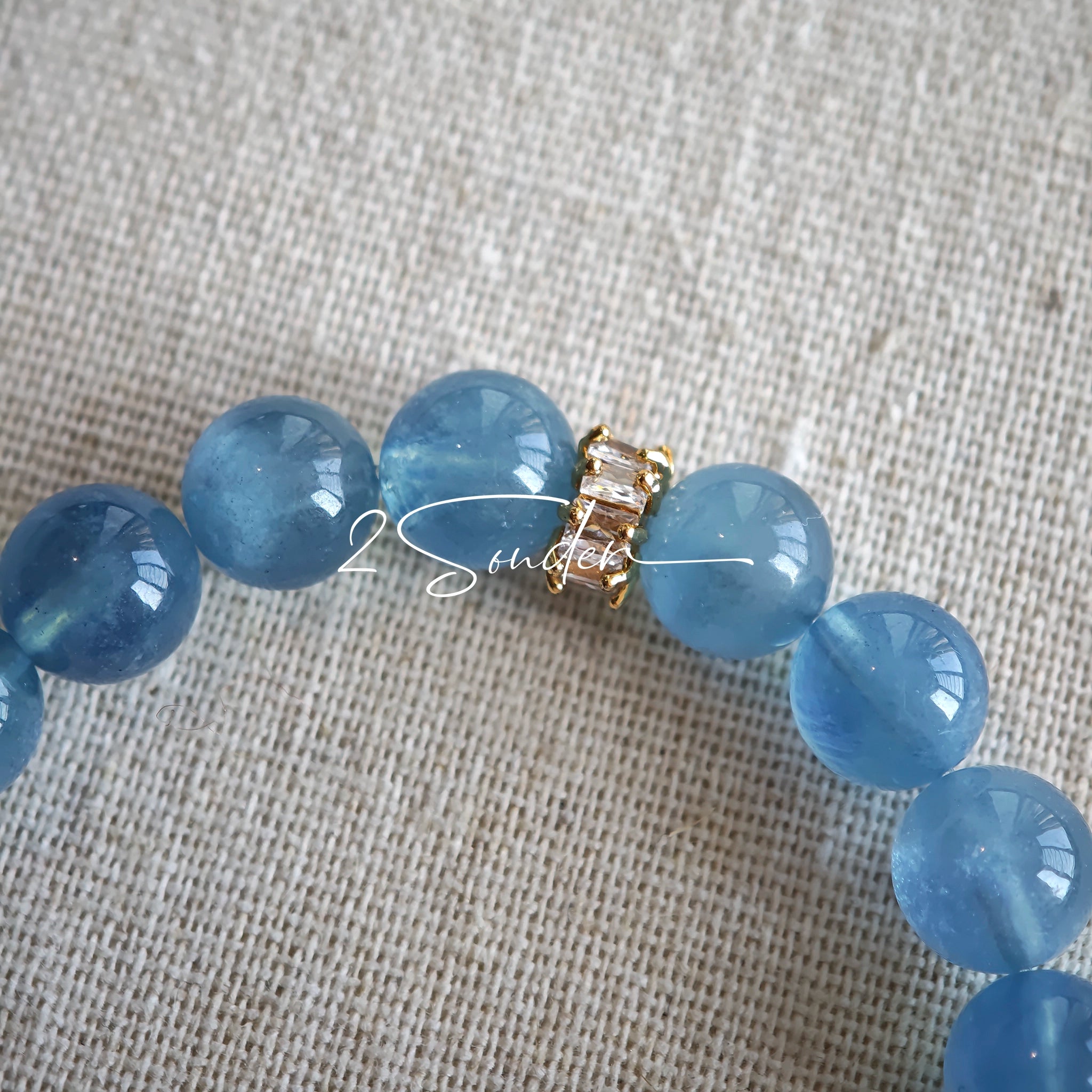 This is a gemstone bracelet that consists of 19pcs of 7-8mm aquamarine beads and 1pcs of red rutilated quartz. There are also 2 silver spacer beads in the bracelet. The main color of the bracelet is sky blue. The entire bracelet is translucent and beautiful.