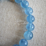 This is a gemstone bracelet that consists of 19pcs of 7-8mm aquamarine beads and 1pcs of red rutilated quartz. There are also 2 silver spacer beads in the bracelet. The main color of the bracelet is sky blue. The entire bracelet is translucent and beautiful.
