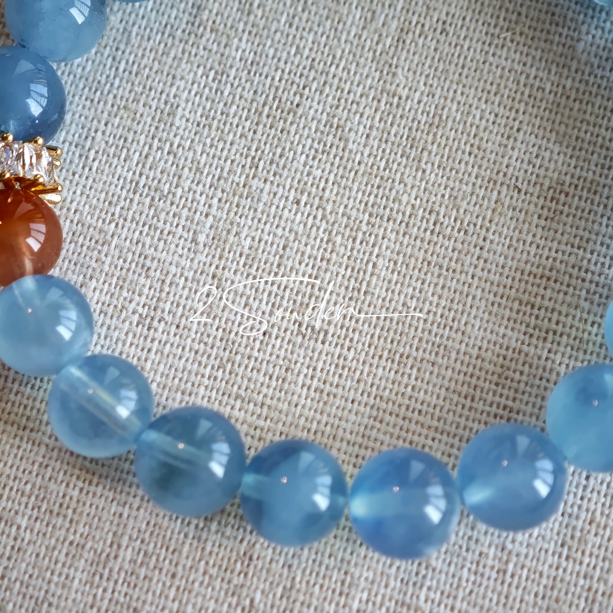 This is a gemstone bracelet that consists of 19pcs of 7-8mm aquamarine beads and 1pcs of red rutilated quartz. There are also 2 silver spacer beads in the bracelet. The main color of the bracelet is sky blue. The entire bracelet is translucent and beautiful.