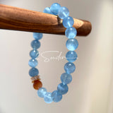 This is a gemstone bracelet that consists of 19pcs of 7-8mm aquamarine beads and 1pcs of red rutilated quartz. There are also 2 silver spacer beads in the bracelet. The main color of the bracelet is sky blue. The entire bracelet is translucent and beautiful.