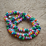 This is a bead necklace that consists of colorful peanut shape beads. It's as colorful as rainbow.