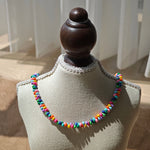 This is a bead necklace that consists of colorful peanut shape beads. It's as colorful as rainbow.